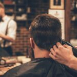 Friseur schneidet einem Mann die Haare