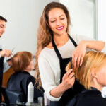 Hairdressers styling clients' hair in modern salon