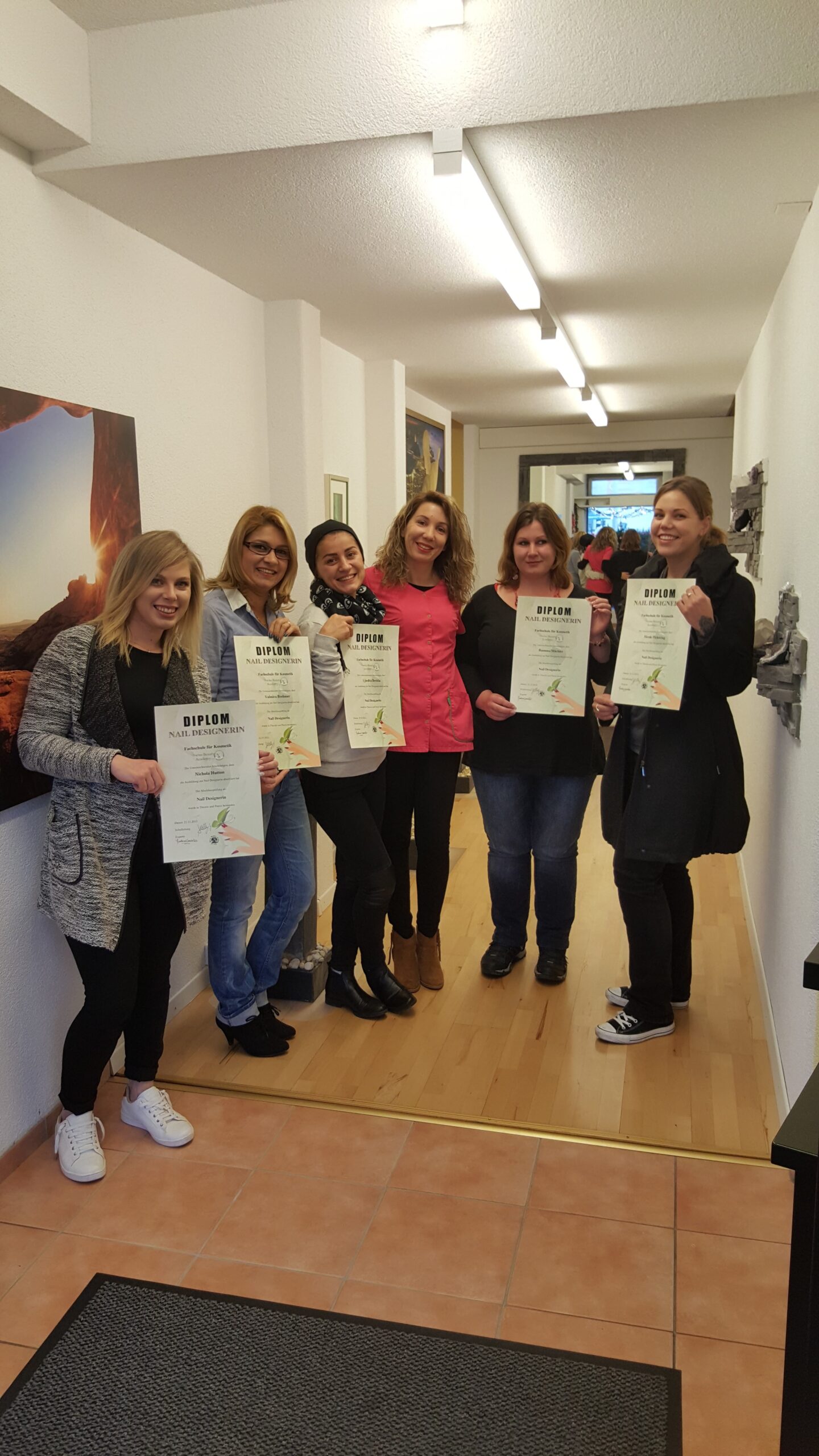 Sechs Frauen mit Nail-Designer-Diplomen im Flur