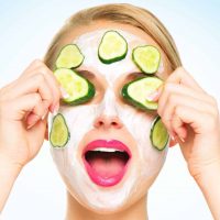 Frau mit Gesichtsmaske und Gurkenscheiben
