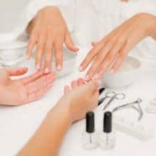 Manicurist performing professional nail care treatment